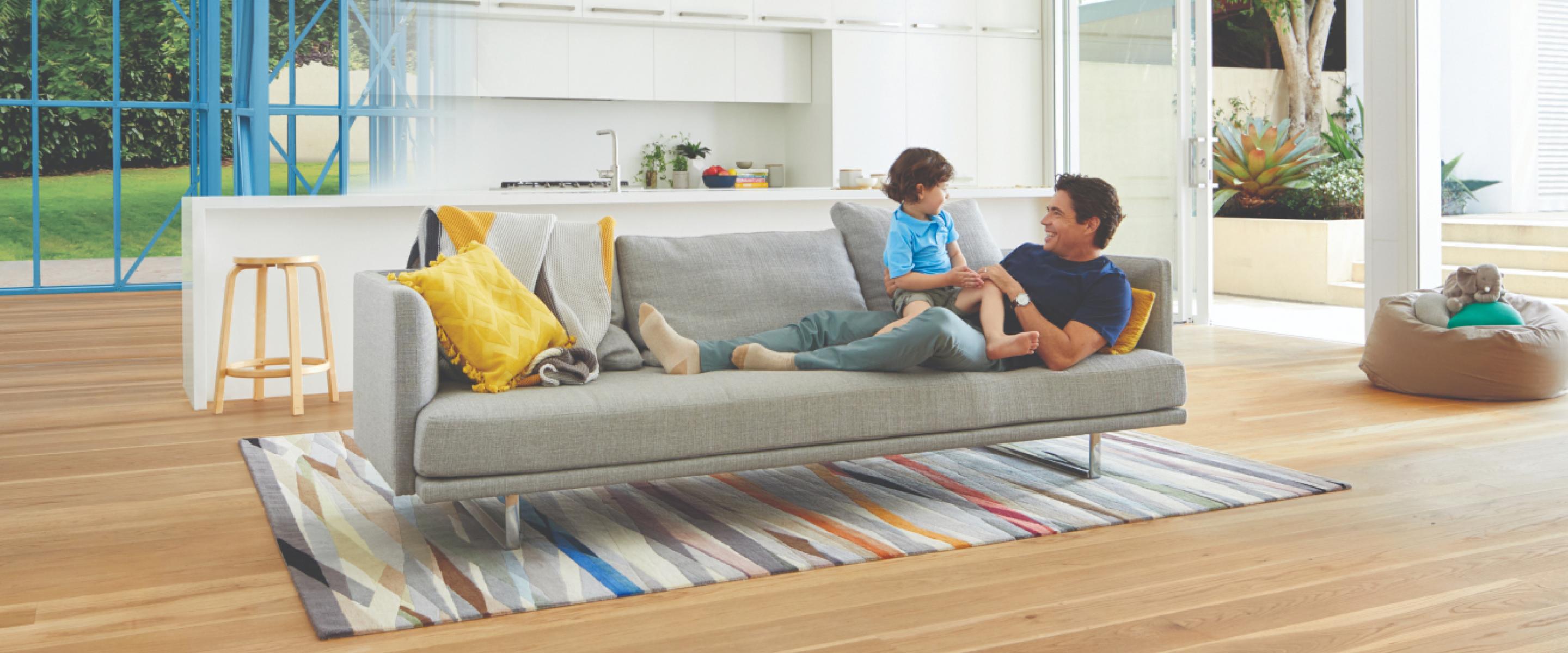 TRUECORE steel QLDbuilder promo_father and son on a grey lounge in a house made from blue steel frames